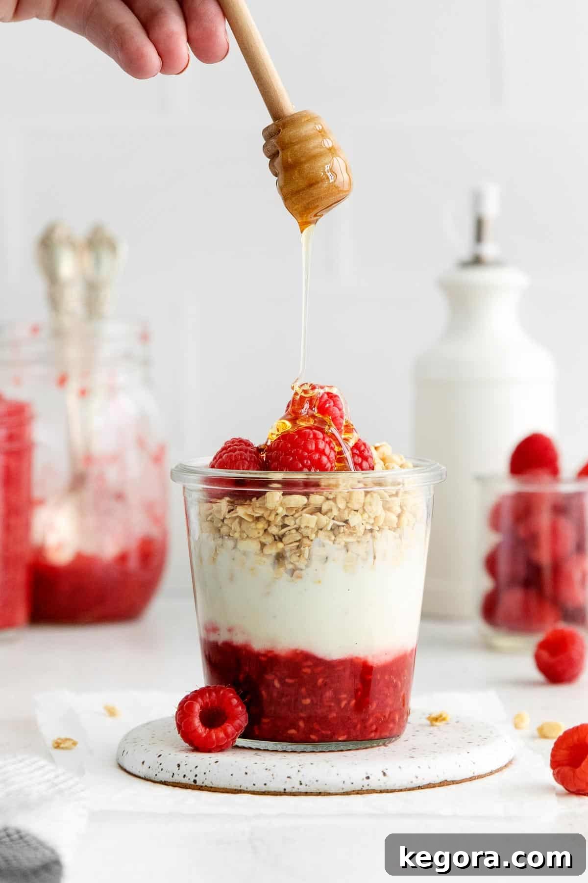 Effortless Raspberry Delight 5 Beautifully layered raspberry compote parfait in a jar with yogurt, crunchy granola, and fresh raspberries, ready to be enjoyed.