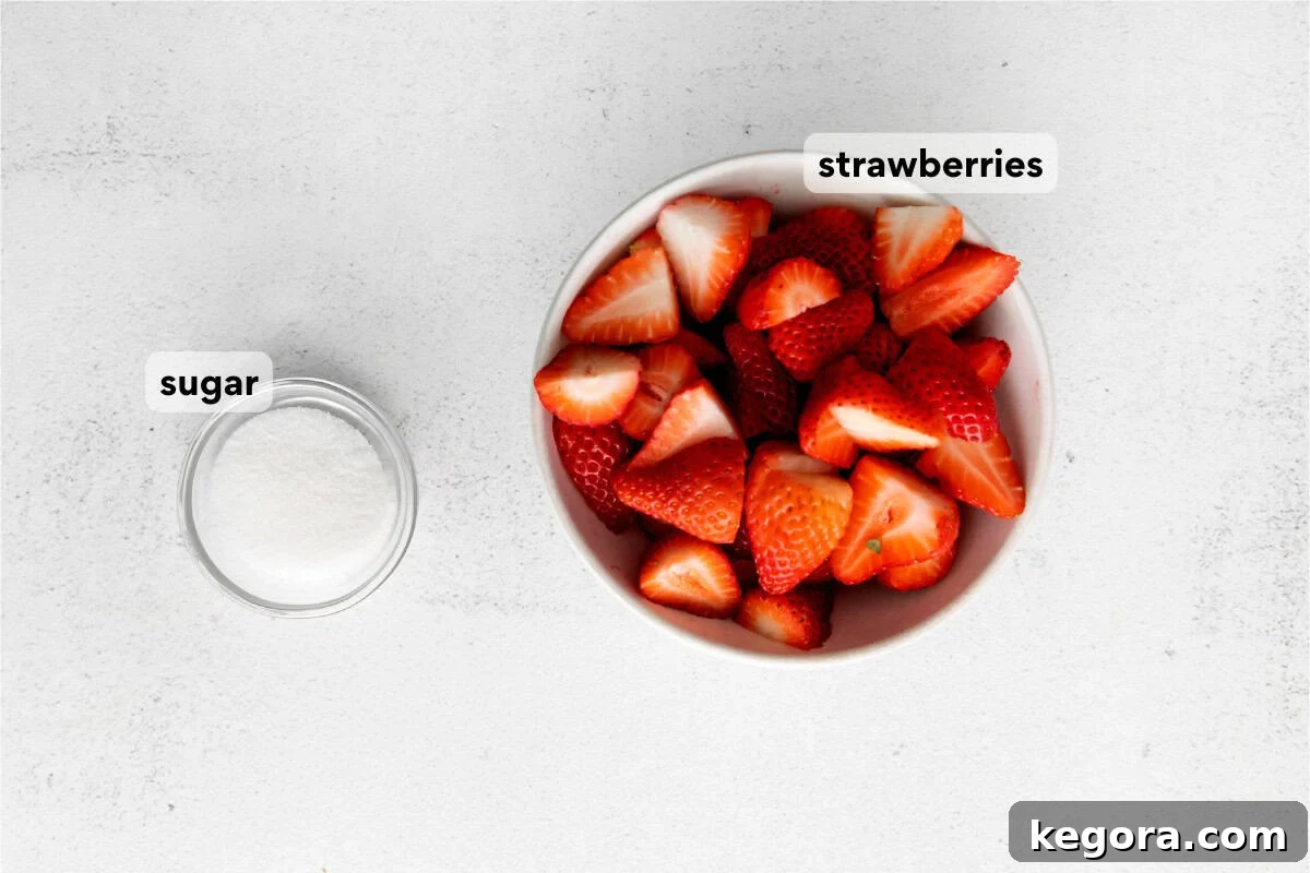 Luscious Strawberry Compote 4 A flat lay of fresh strawberries, granulated sugar, and a lemon on a wooden countertop, representing the simple ingredients for strawberry compote