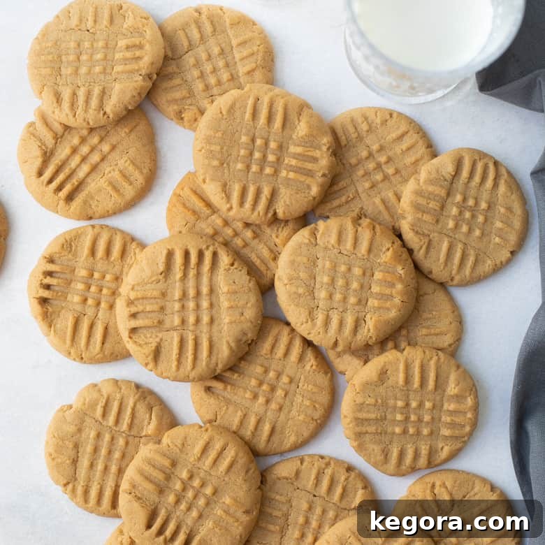 An inviting overhead shot of delicious gluten-free peanut butter cookies on a marble background with a glass of milk.