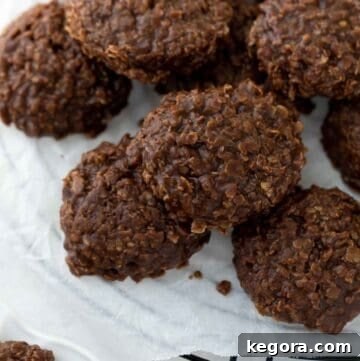 A close-up of delicious gluten-free no-bake cookies cooling on a black rack with white parchment paper.