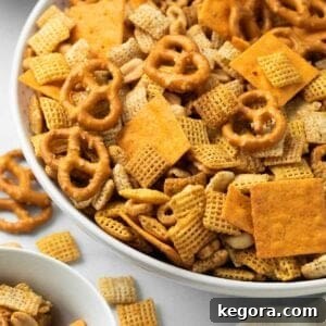 A close-up image of savory gluten-free Chex mix in a pristine white bowl.