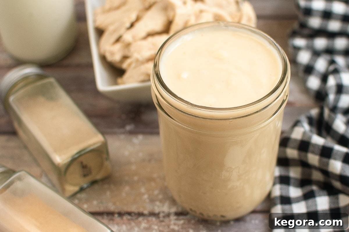 Jar of cream soup on a board with checkered napkin and chicken in background.