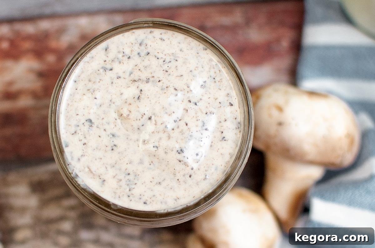 Thick and Creamy Homemade Mushroom Soup 3 A close-up shot looking down into a jar of homemade cream of mushroom soup, showcasing its thick and creamy texture.