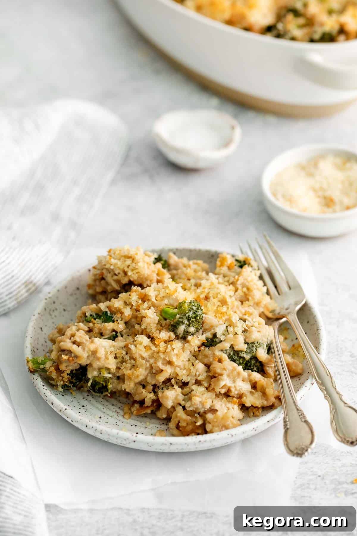 Wholesome Dairy-Free Gluten-Free Chicken Rice Bake 8 A generous serving of dairy-free chicken and rice casserole on a white plate, garnished with fresh herbs.