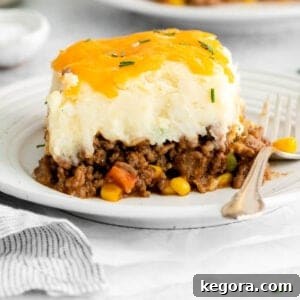 A portion of shepherd's pie on a plate, showcasing the golden mashed potato topping.