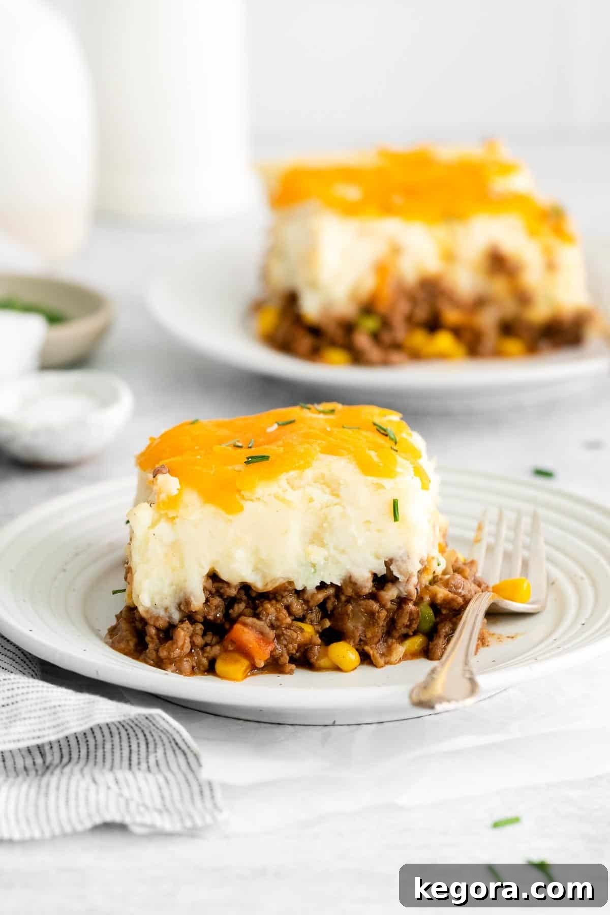 Wholesome Gluten-Free Shepherd's Pie 3 A serving of shepherd's pie with a fork on a plate, highlighting the creamy mashed potato topping and savory meat filling.