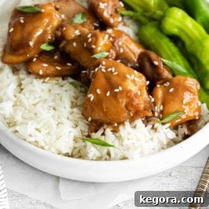A bowl of chicken, rice, snap peas, and teriyaki sauce with chopsticks on the side