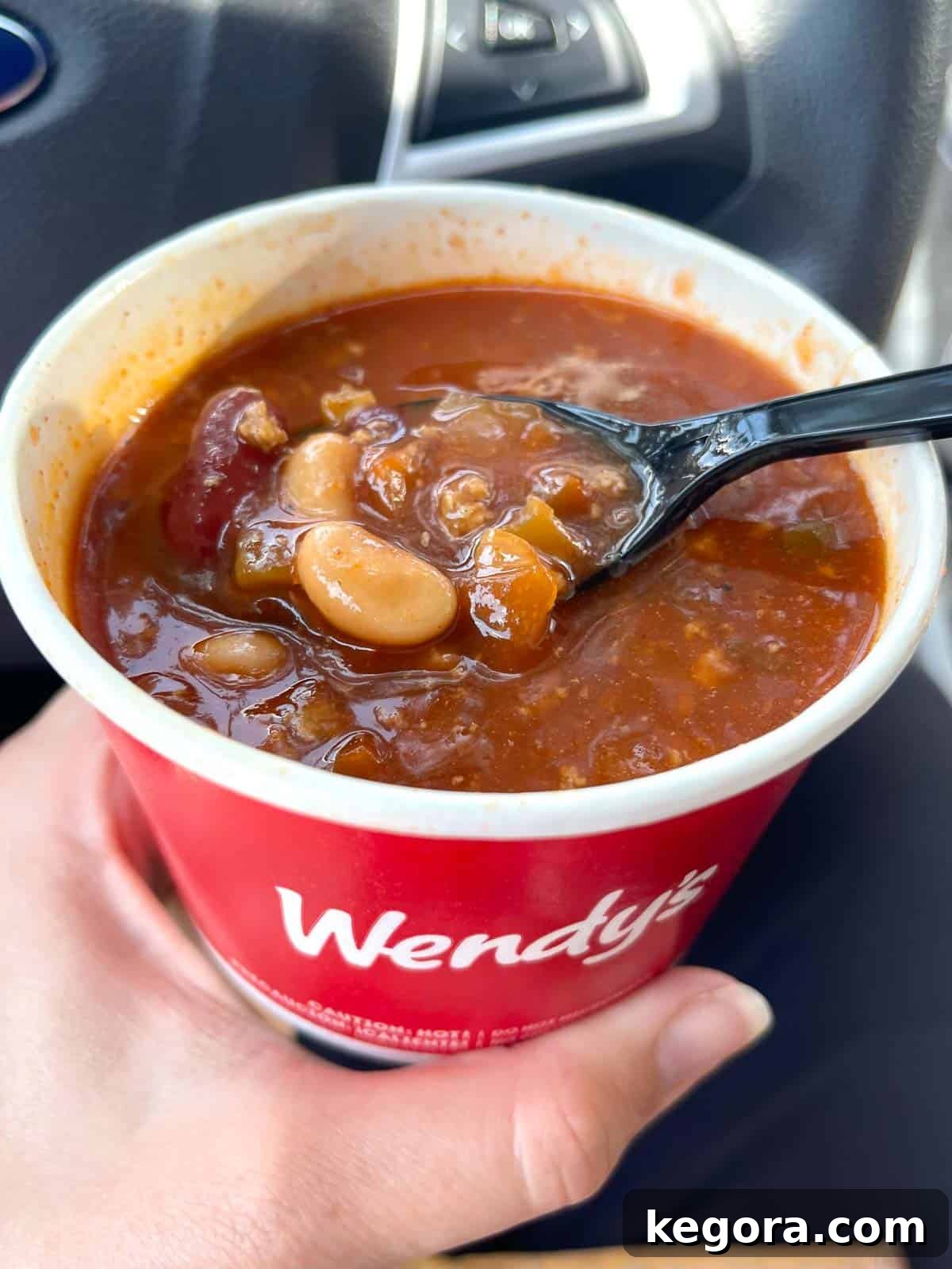 Wendy's chili in a cup with a spoon in it