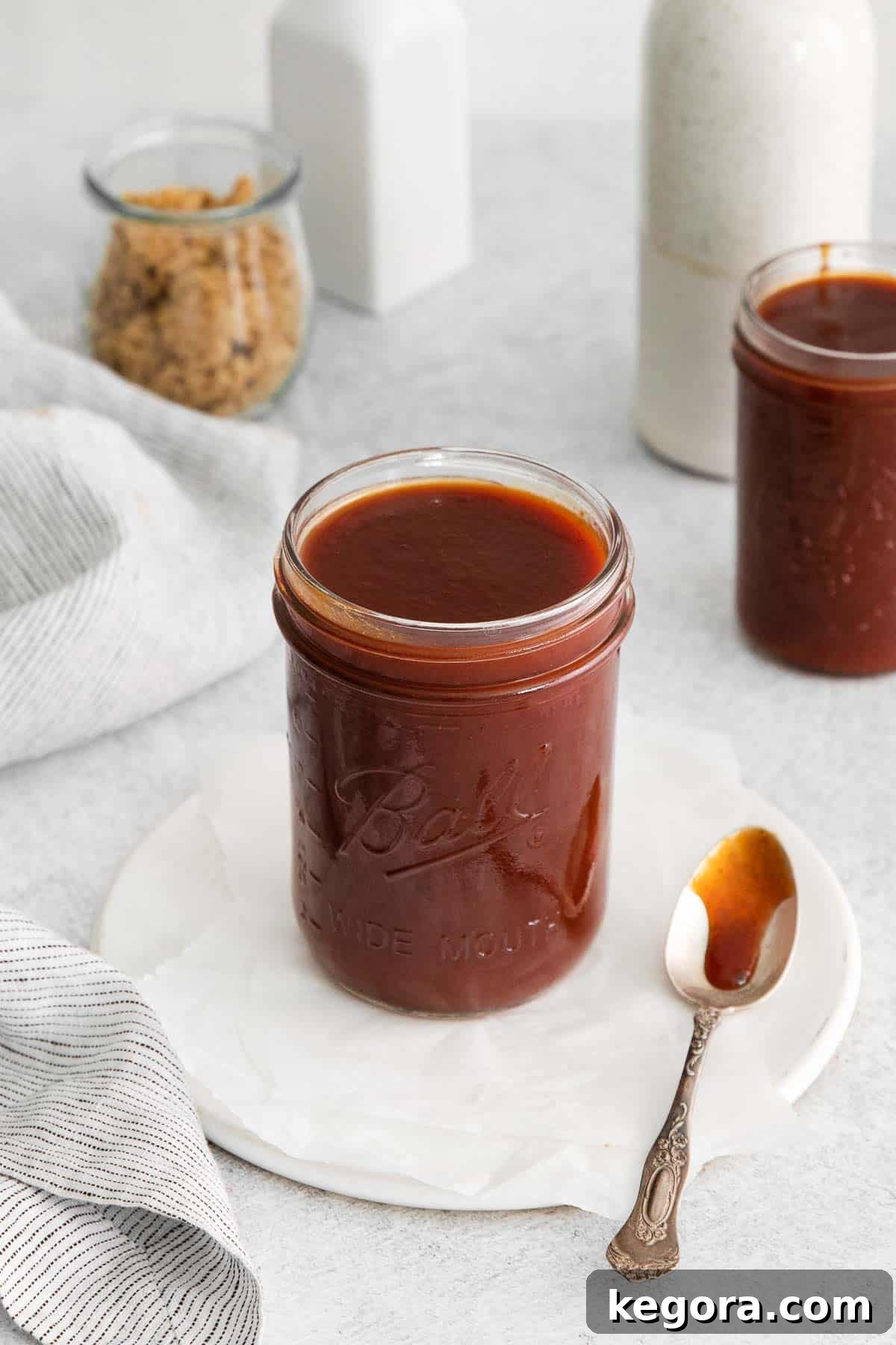 Gluten-free BBQ sauce in a glass jar, with a spoon next to it
