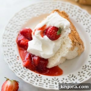 slice of gluten-free angel food cake on white plate with strawberries