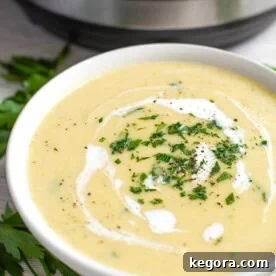 Potato Leek Soup in a white bowl with a pressure cooker in the background
