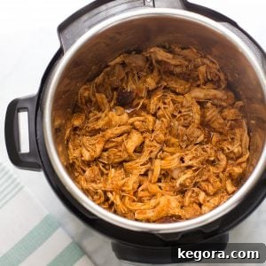 bbq chicken in instant pot with marble background and blue striped towel