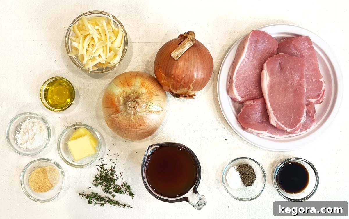 Ingredients laid out for Slow Cooker French Onion Pork Chops: pork chops, onions, butter, olive oil, beef broth, thyme, Worcestershire sauce, salt, pepper, garlic powder, onion powder, and Gruyère cheese.