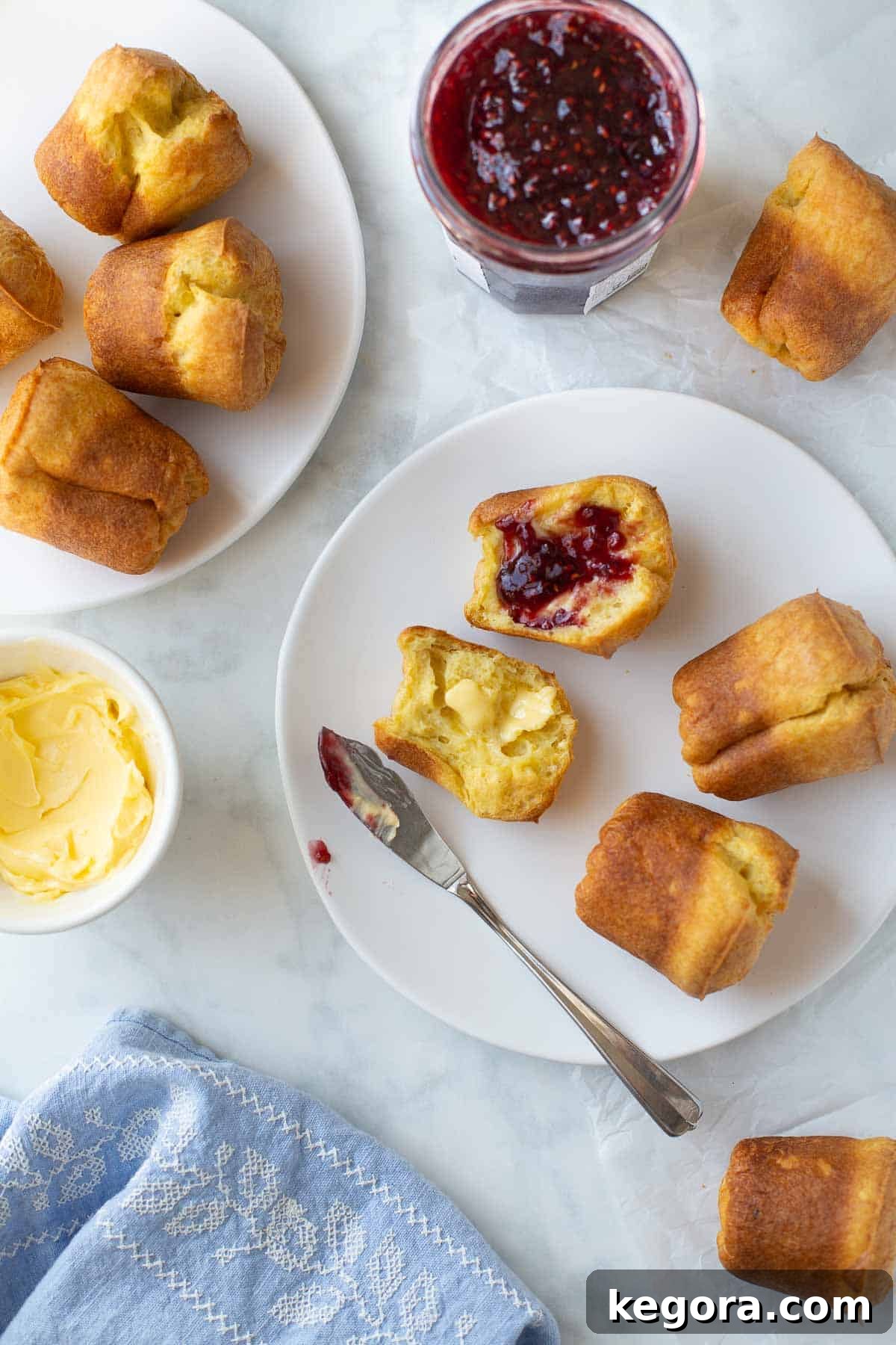 Gluten-Free Popovers An inviting overhead shot of golden-brown gluten-free popovers served with fresh butter and sweet jam, highlighting their perfect rise and crisp texture.