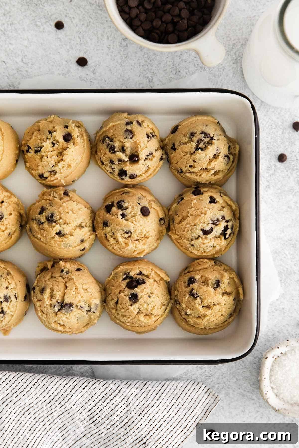 Safe and Scrumptious Gluten-Free Cookie Dough 7 Perfectly round gluten-free edible cookie dough balls arranged on a parchment-lined cookie sheet