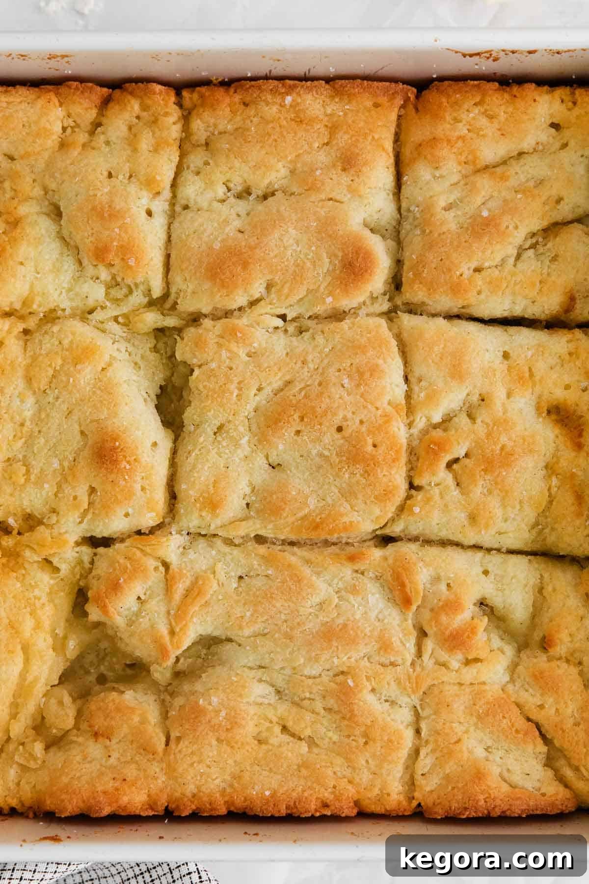 Butter-Dipped Gluten-Free Biscuits 2 A close-up of golden brown, fluffy gluten-free biscuits in a baking dish, perfectly baked and ready to serve.