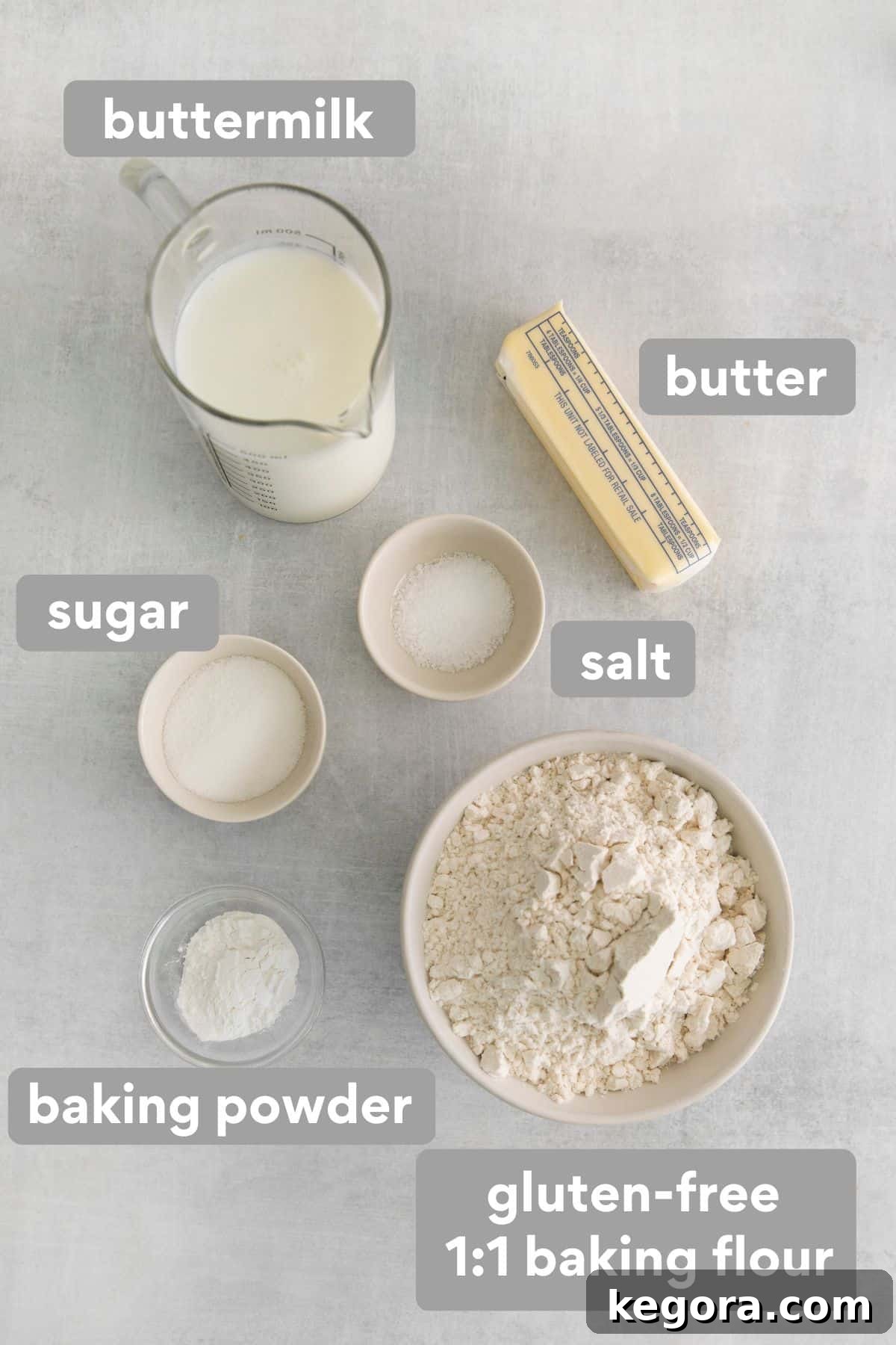 Butter-Dipped Gluten-Free Biscuits 4 A flat lay of all the dry and wet ingredients needed to make gluten-free biscuits, including flour, buttermilk, butter, and seasonings.