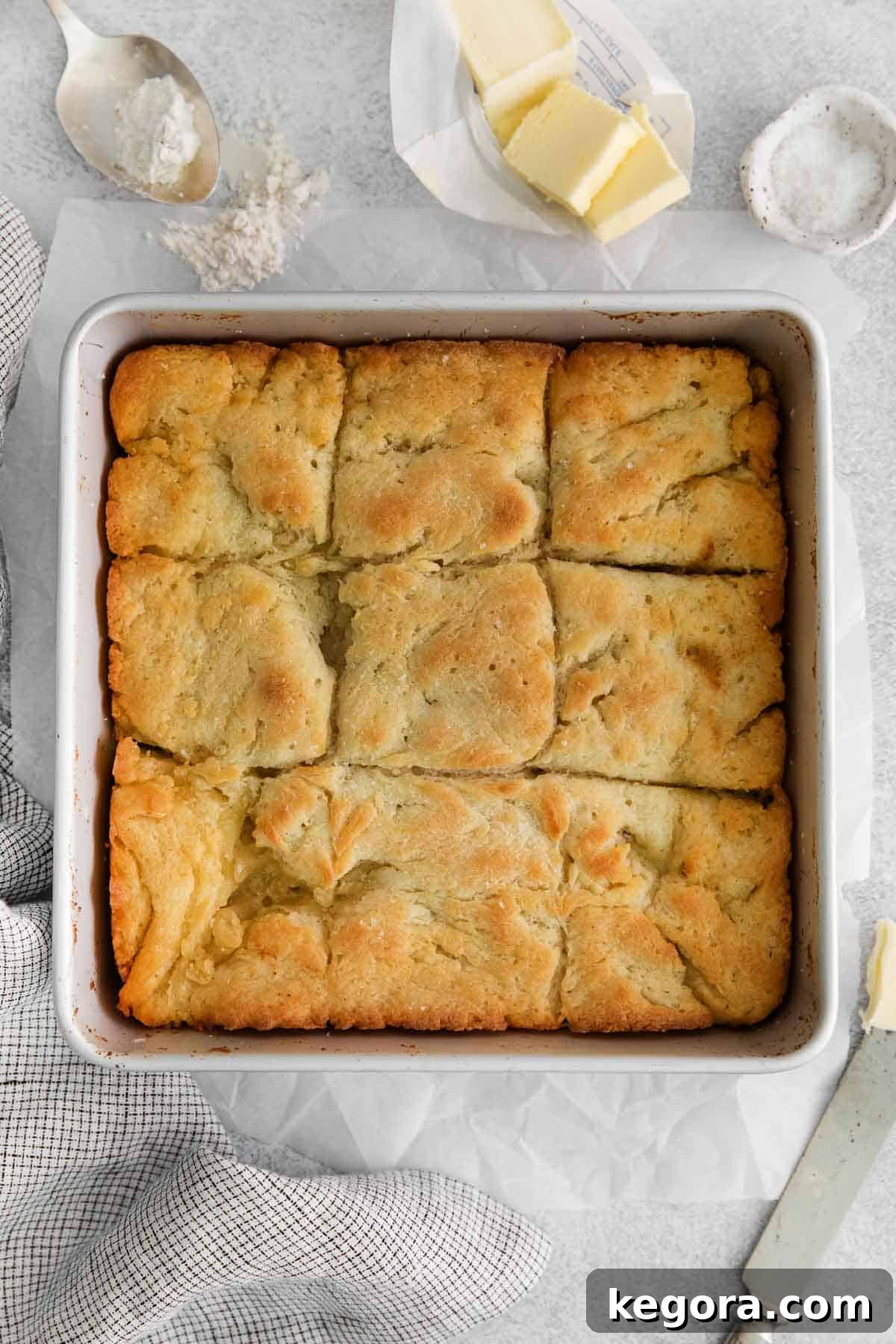 Butter-Dipped Gluten-Free Biscuits 8 An overhead view of golden-brown gluten-free biscuits in a baking dish, with steam subtly rising, highlighting their freshness.