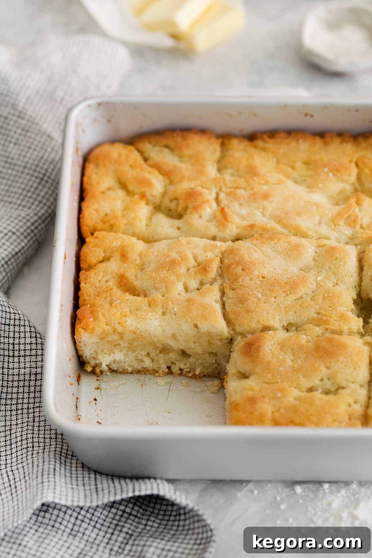 Butter-Dipped Gluten-Free Biscuits 9 A close-up of gluten-free biscuits in a baking dish, with one biscuit gently pulled out, revealing its fluffy interior.