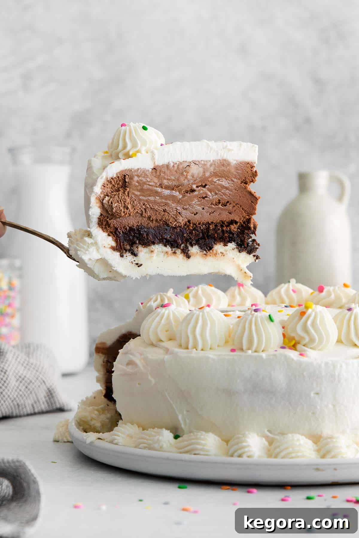 A beautifully sliced gluten-free ice cream cake on a countertop, with a piece being served, revealing its delightful layers.