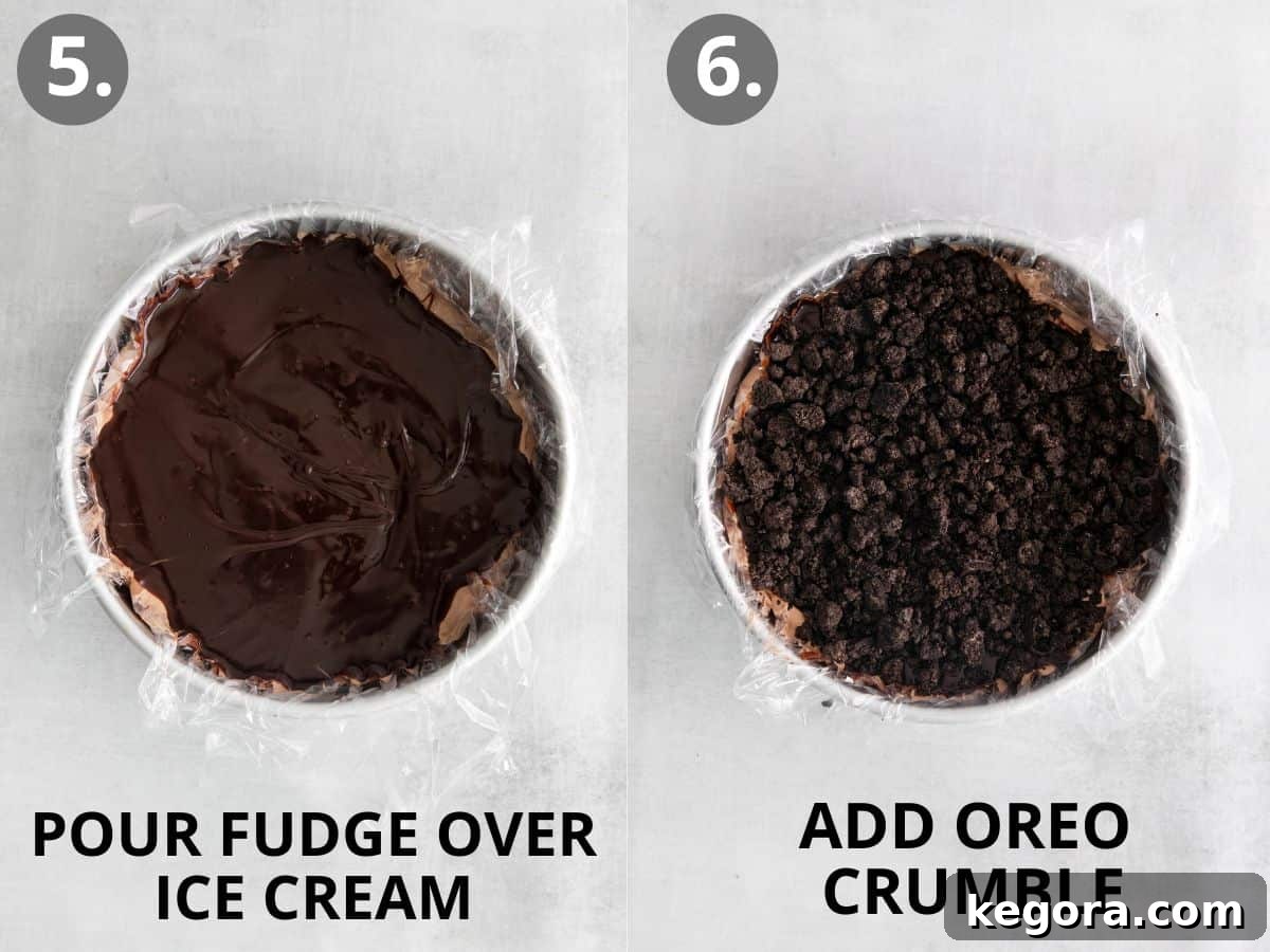 A layer of rich fudge being poured over the chocolate ice cream, followed by an even sprinkle of cookie crumbles, showcasing the progressive layering of the cake.