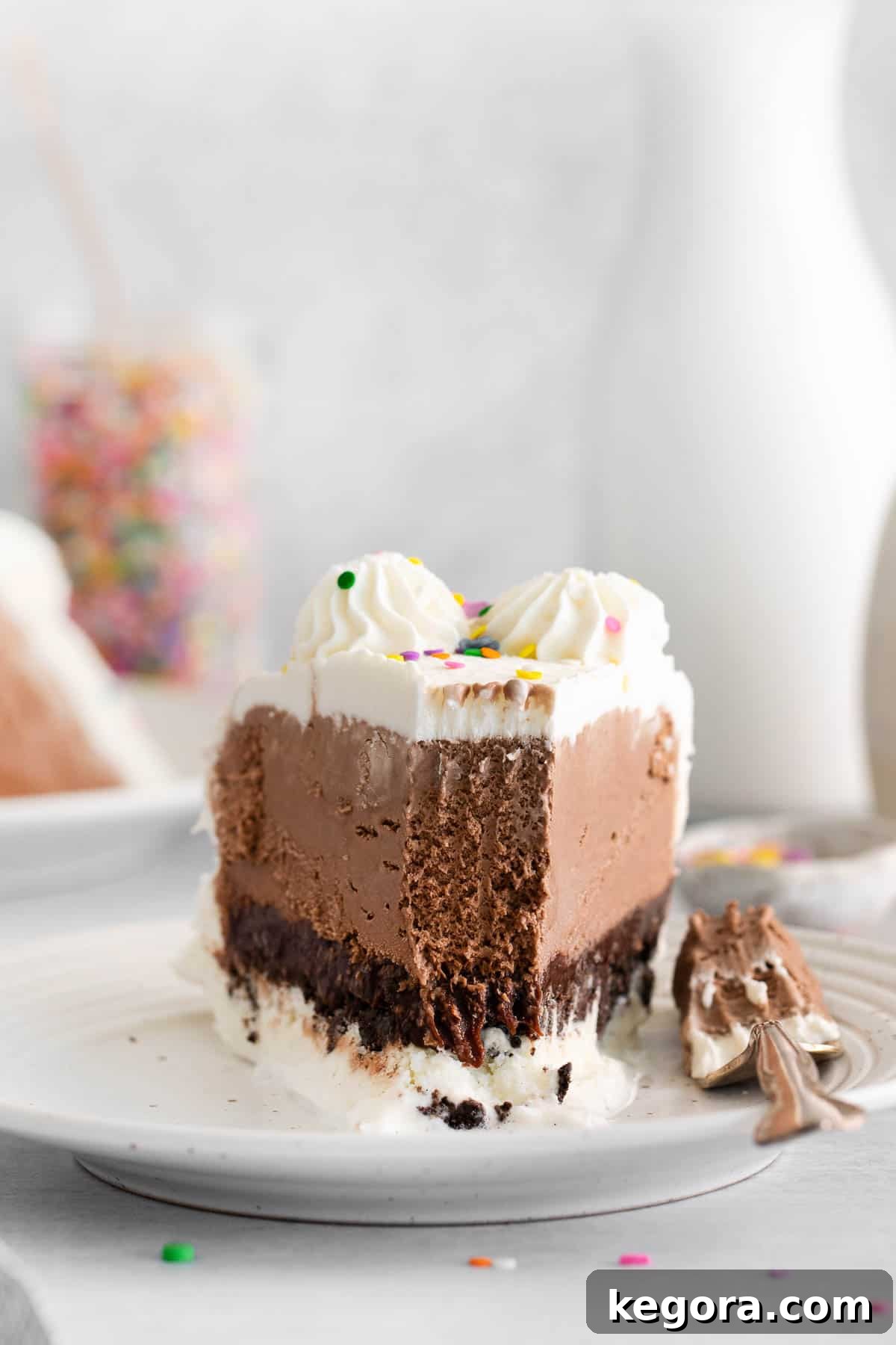 A tempting slice of gluten-free ice cream cake on a plate, with a bite taken out, inviting a taste.