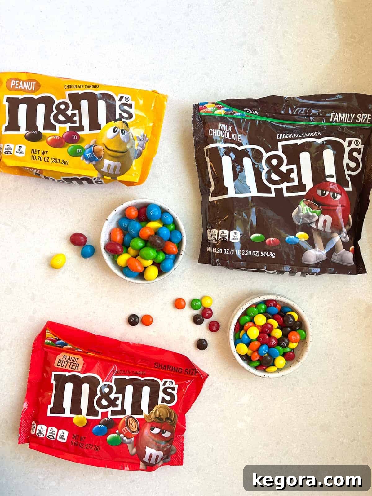 Your Gluten-Free Guide to M&Ms 3 3 bags of M&Ms on white counter with 2 bowls of open mms