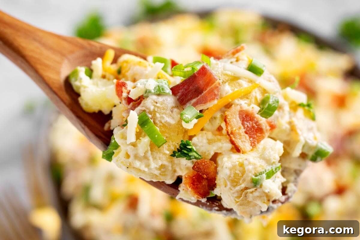 Creamy Bacon Cheddar Potato Salad 3 Loaded Potato Salad on wood spoon closeup