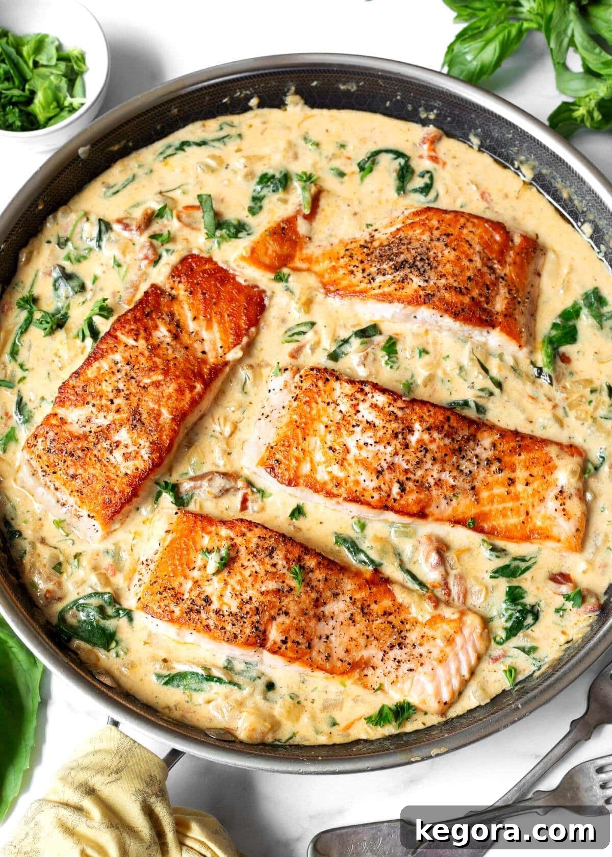 Decadent Creamy Garlic Tuscan Salmon 2 Four Creamy Garlic Tuscan Salmon fillets nestled in a pan of rich, vibrant sauce.