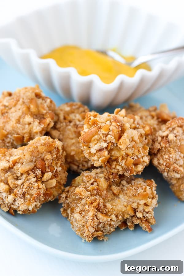 Irresistibly crispy gluten-free pretzel crusted chicken bites on a baking sheet, ready to be served, highlighting their golden-brown color and crunchy texture.