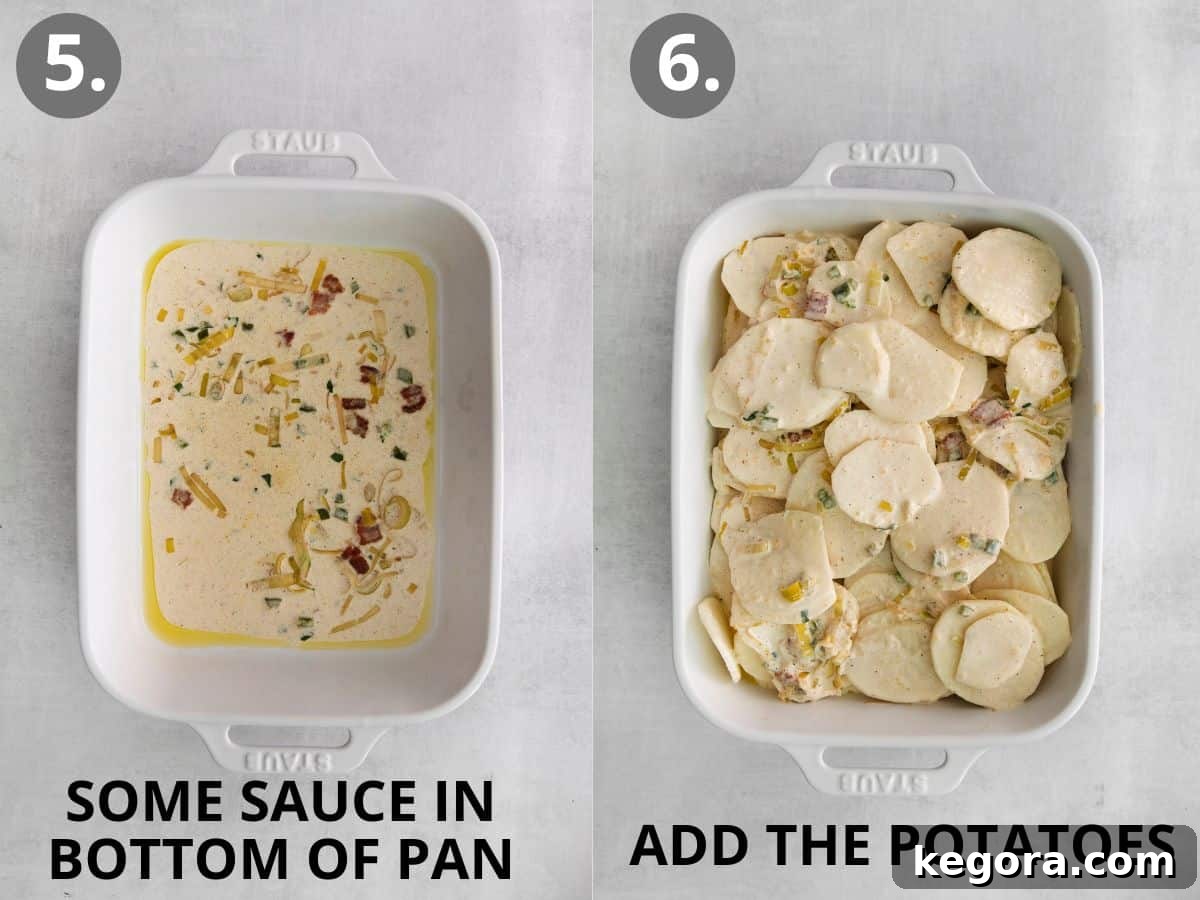 A greased casserole dish with a thin layer of cheese sauce at the bottom, followed by layers of thinly sliced potatoes, and then the remaining cheese sauce poured over the top, ready for baking.