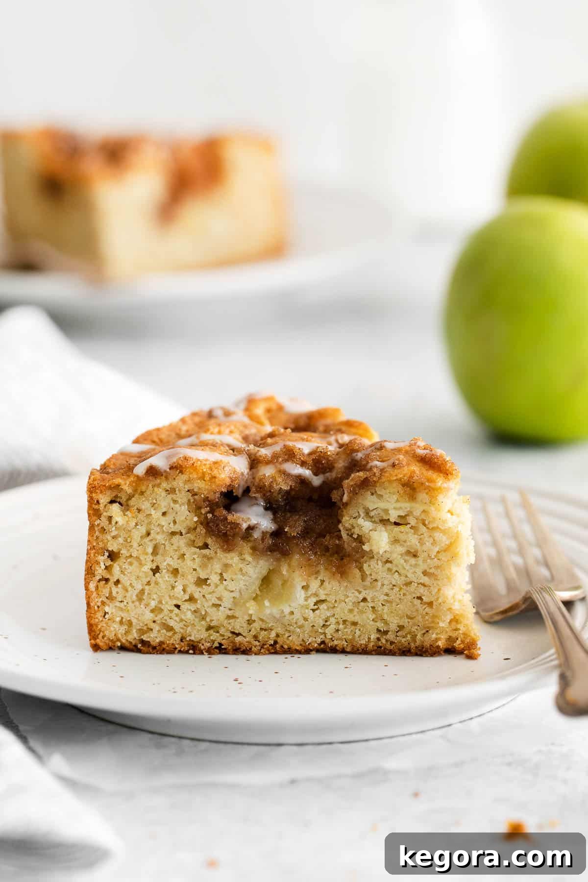 Homestyle Gluten-Free Apple Cake 3 A side view of a perfectly sliced gluten-free apple cake, showing the layers of thin apple slices and the moist cake texture.