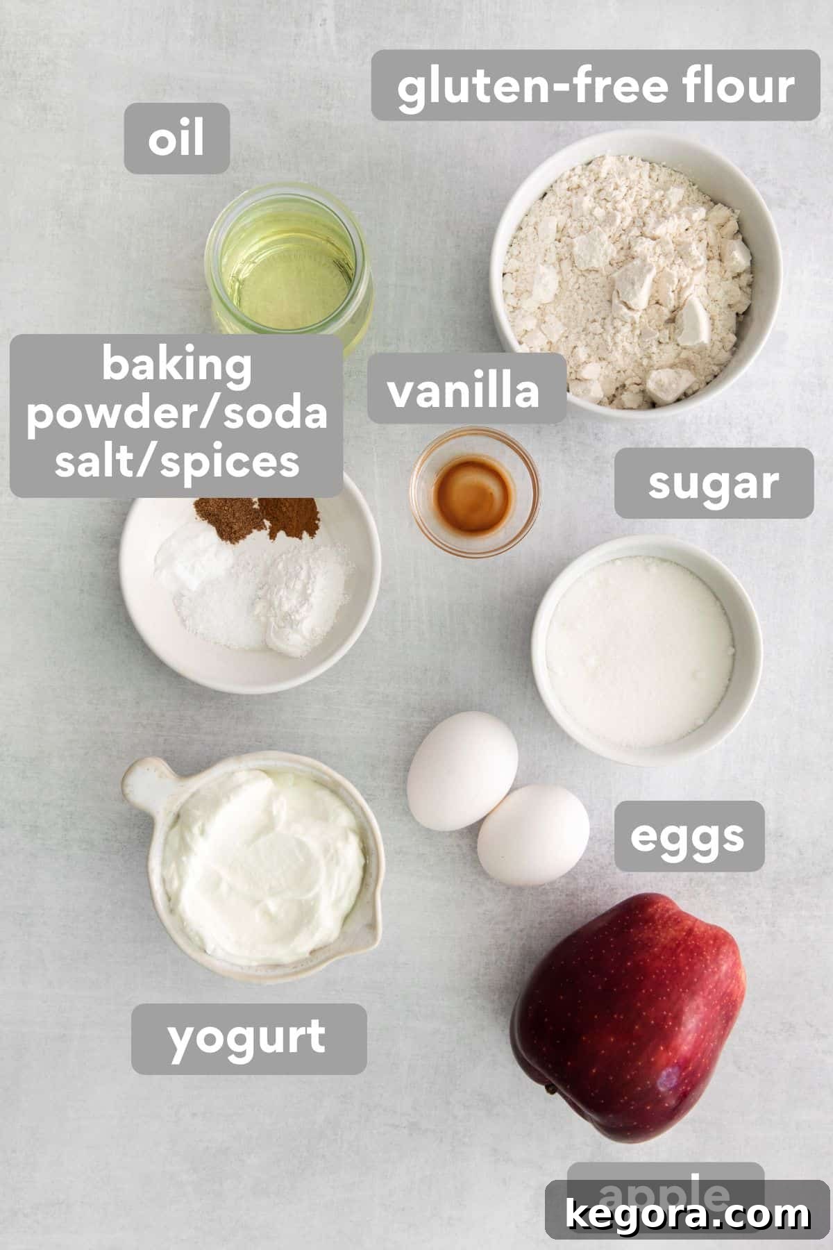 Homestyle Gluten-Free Apple Cake 4 Individual ingredients for gluten-free apple cake laid out neatly on a kitchen counter, including flour, sugar, apples, eggs, and spices.