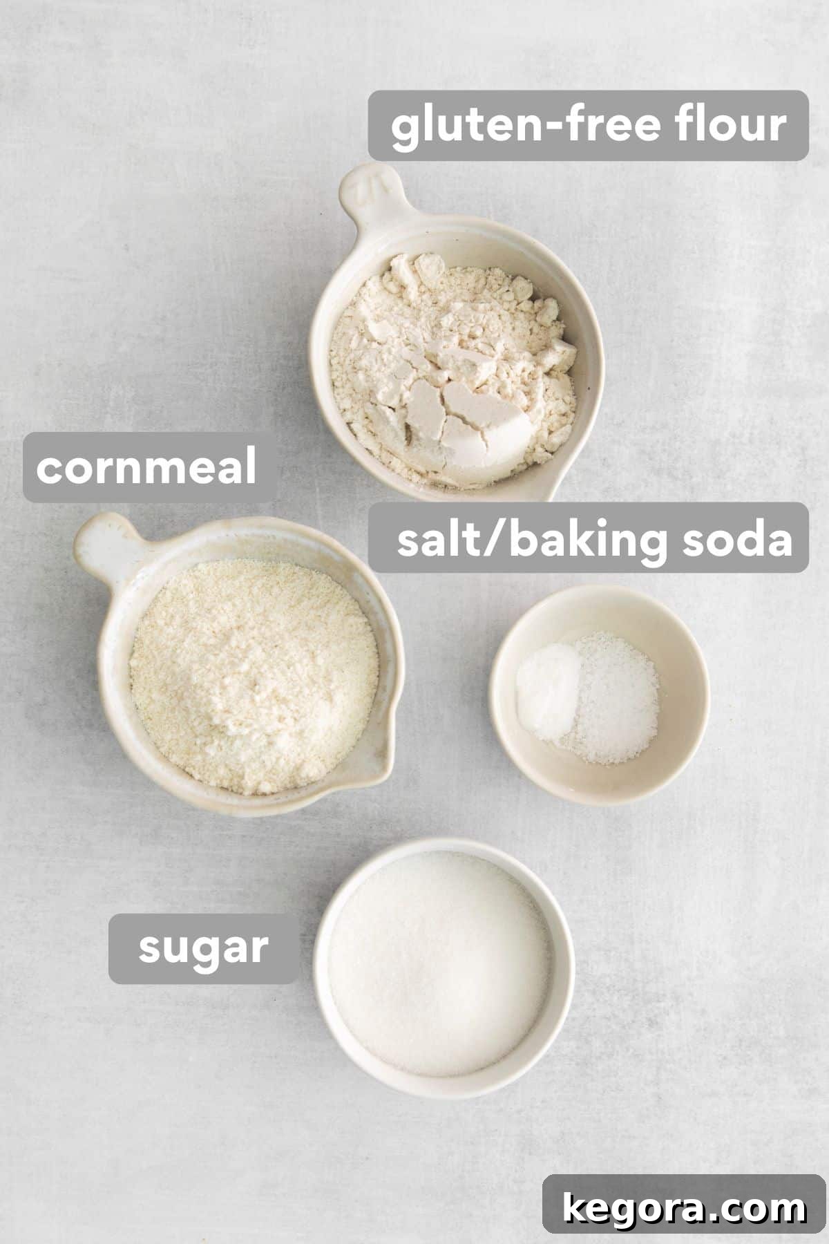 Creamy Gluten-Free Corn Bake 3 Carefully arranged ingredients for homemade gluten-free cornbread mix on a rustic kitchen countertop, including flour, cornmeal, and sugar