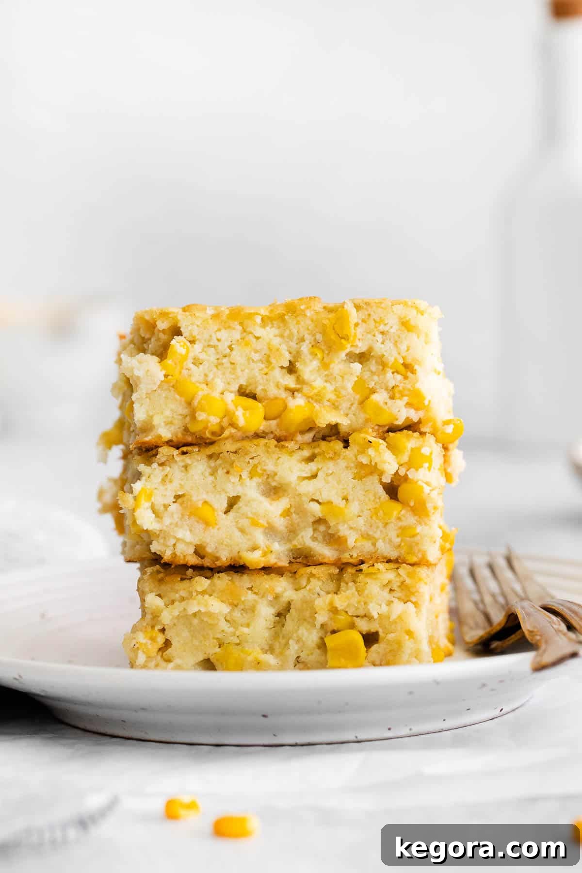 Creamy Gluten-Free Corn Bake 9 Artfully stacked slices of gluten-free corn casserole on a pristine white plate, garnished and ready for serving