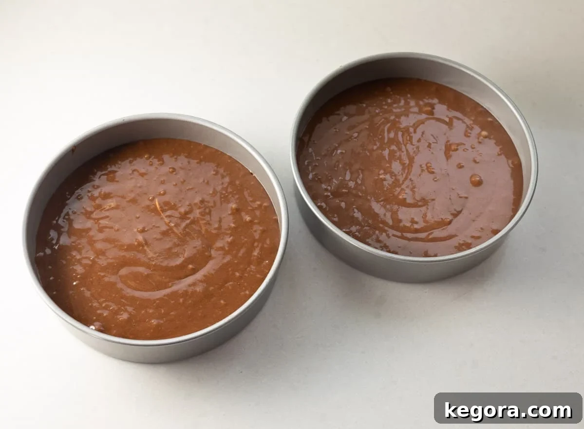 Decadent Gluten-Free German Chocolate Cake 5 Smooth German chocolate cake batter evenly divided into two round baking pans, ready for the oven.