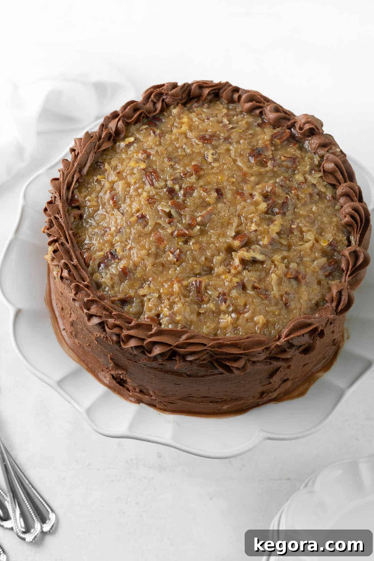 Decadent Gluten-Free German Chocolate Cake 9 A beautifully assembled whole German chocolate cake on a platter, showcasing its rich, layered goodness and iconic coconut-pecan topping.