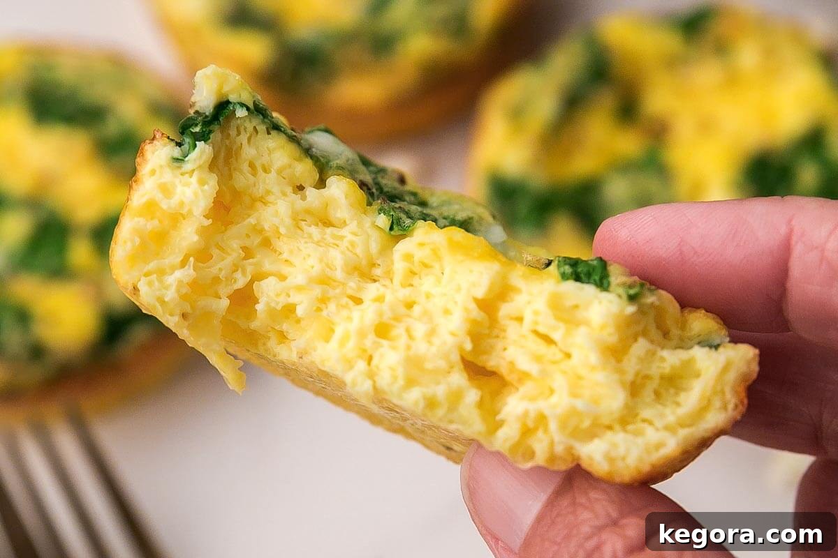 Spinach Feta Egg Muffin in hand with bite gone.