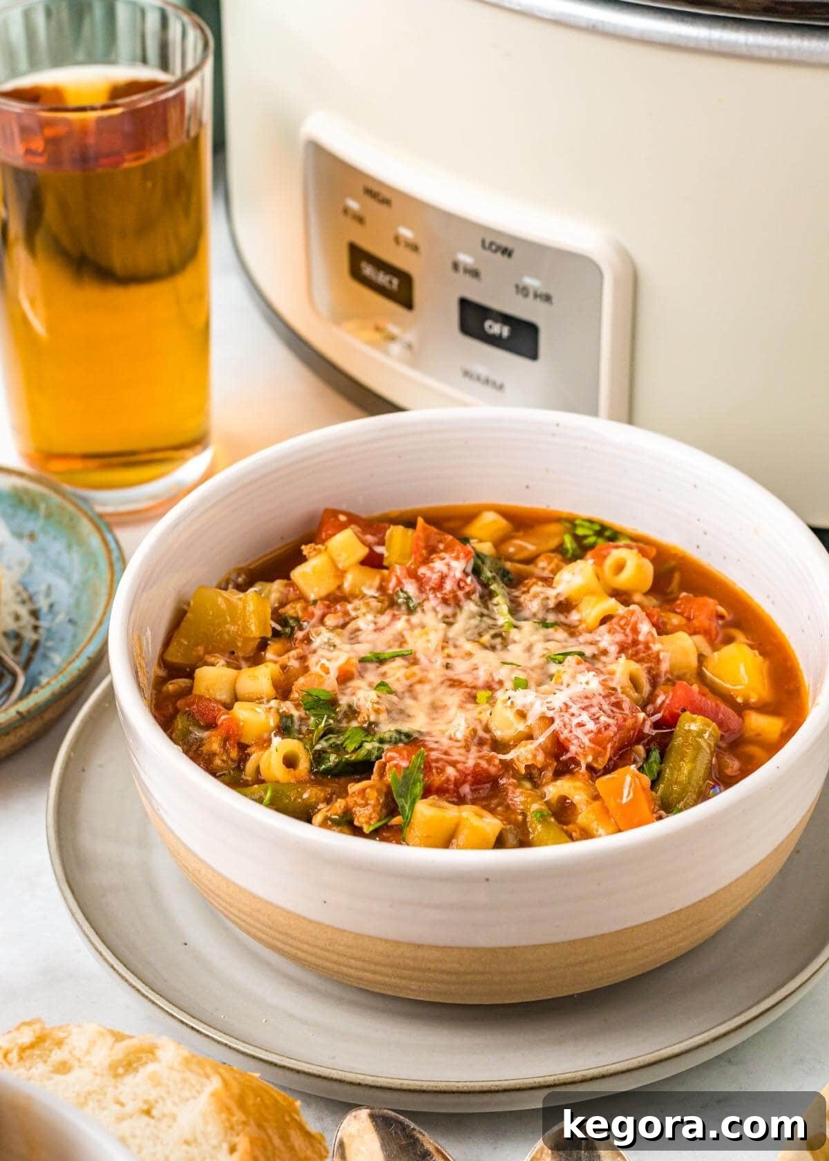 Slow Cooker Minestrone: Effortless & Hearty 3 Slow Cooker Minestrone Soup in white bowl in front of crockpot.