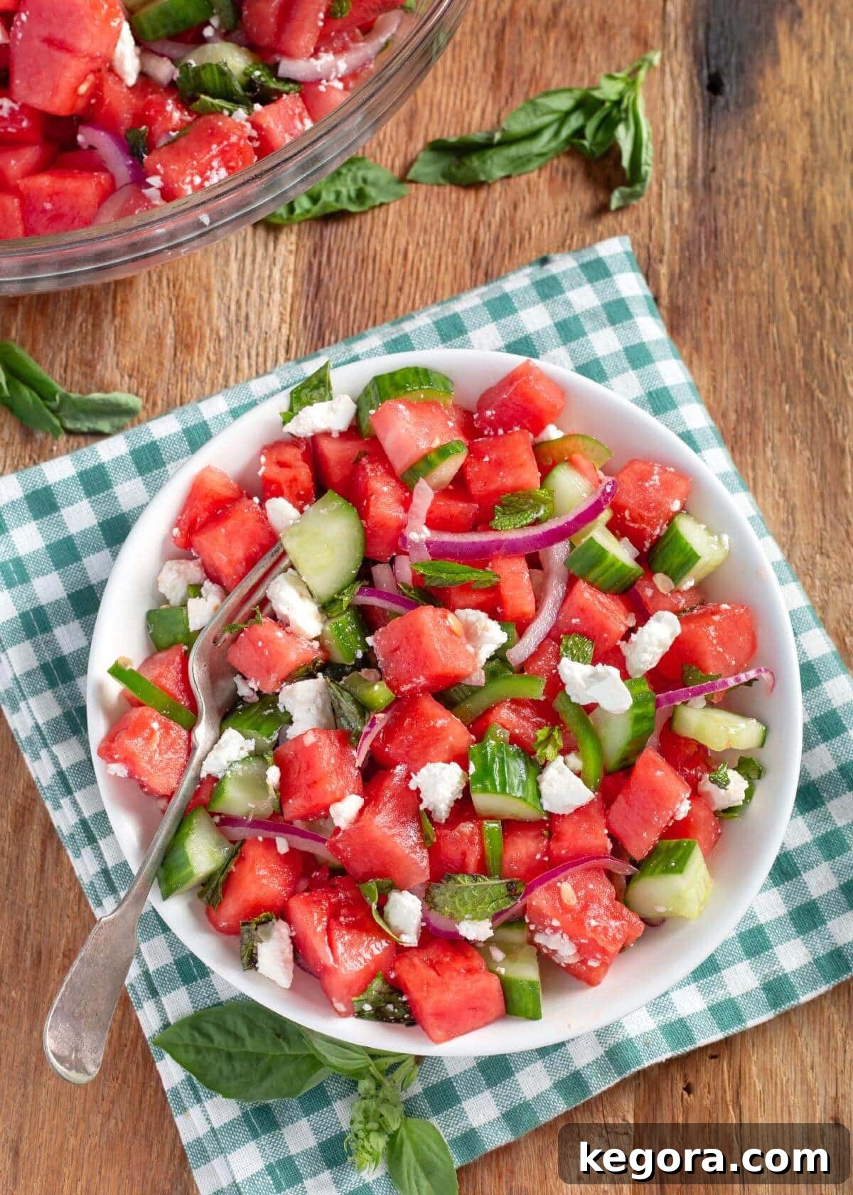 Watermelon Feta Salad in a white bowl on checkered napkin.