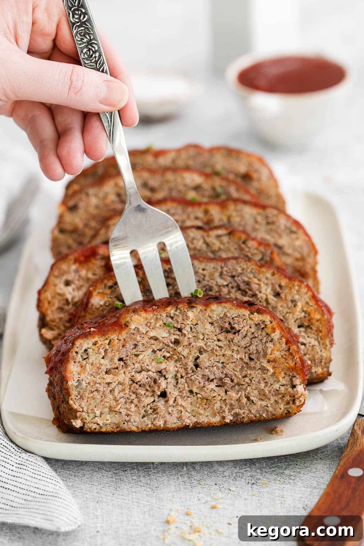 A serving fork picking up a slice of gluten-free meatloaf