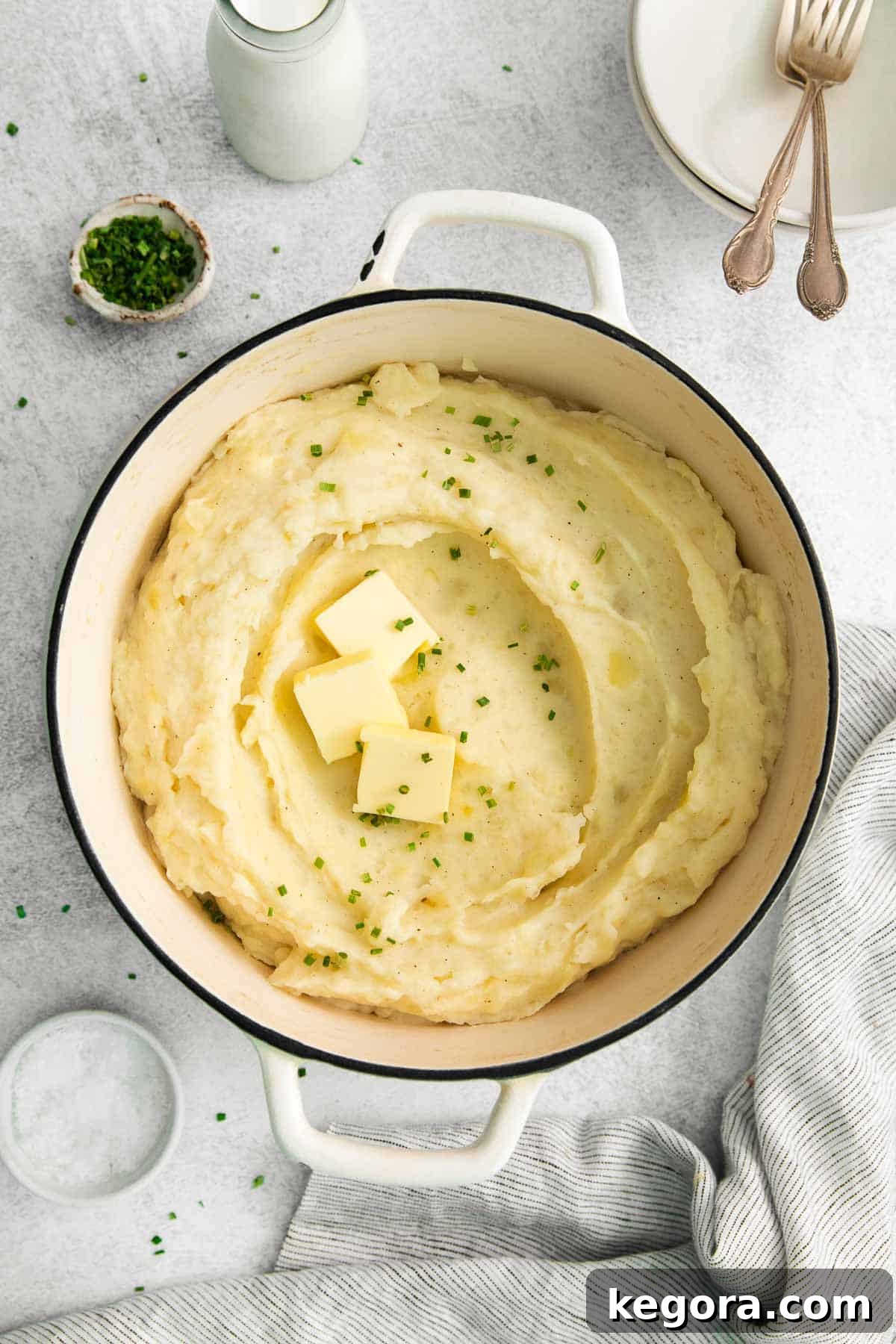Creamy Gluten-Free Mashed Potatoes 2 An overhead view of creamy gluten-free mashed potatoes in a large pot, ready to be served, garnished with fresh herbs.