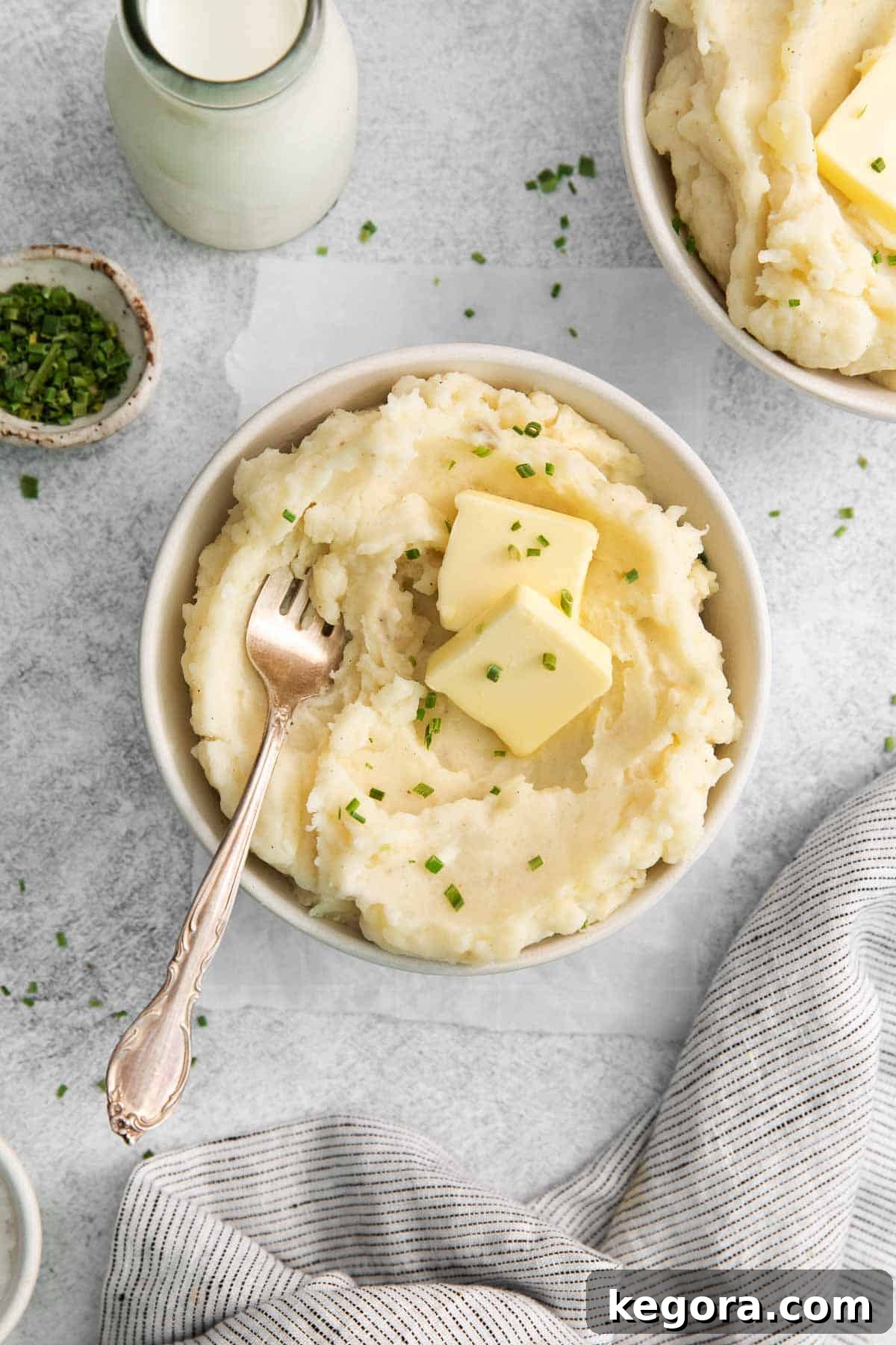Creamy Gluten-Free Mashed Potatoes 6 A beautifully plated bowl of gluten-free mashed potatoes, garnished with a pat of butter, fresh parsley, and a serving spoon, ready to be enjoyed.