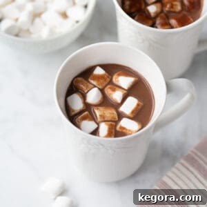 Plant-Based Cocoa Bliss 4 A pristine white mug filled with rich hot chocolate, topped generously with fluffy white marshmallows, embodying cozy comfort.
