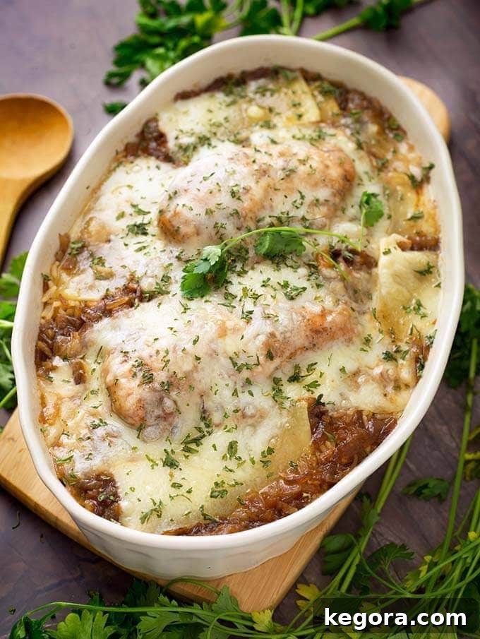 French Onion Chicken and Rice in a white oval shaped bowl on a small wooden board