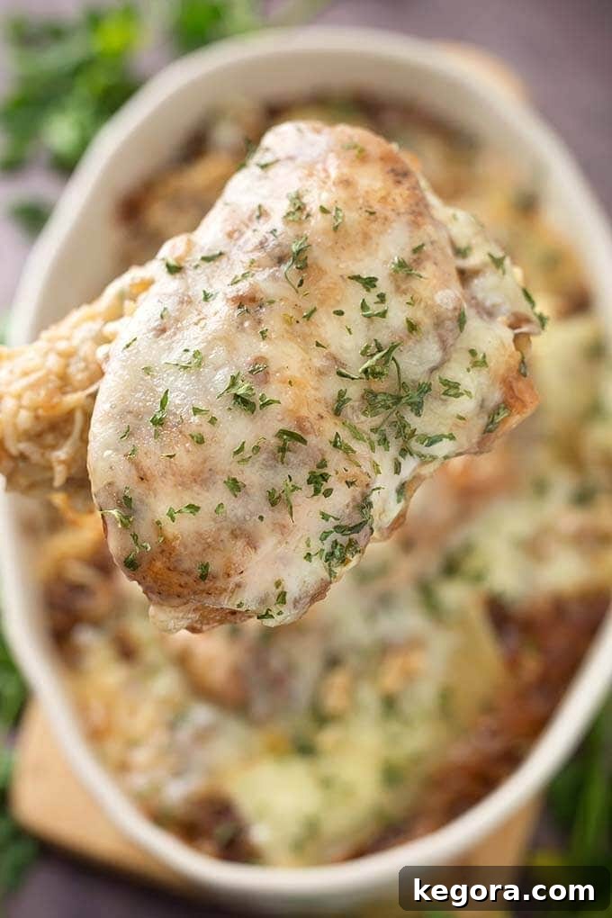 Close up of spoonful of French Onion Chicken and Rice with casserole dish in background
