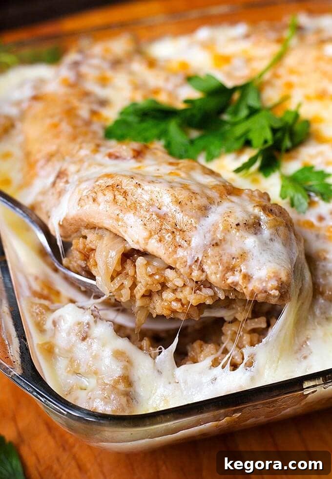 Silver spoon serving French Onion Chicken and Rice from glass casserole dish