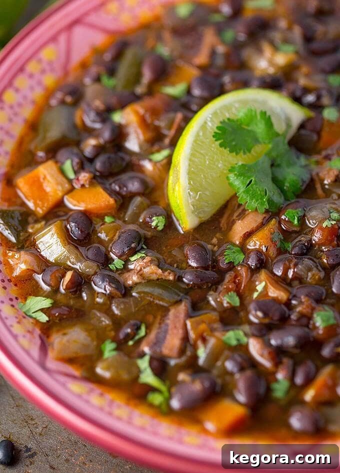 close up of Instant Pot Black Bean Soup in a colorful bowl, showing the creamy texture and bean bits