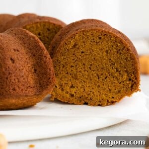 A close-up of an unfrosted gluten-free pumpkin bundt cake, showcasing its moist texture and rich color.