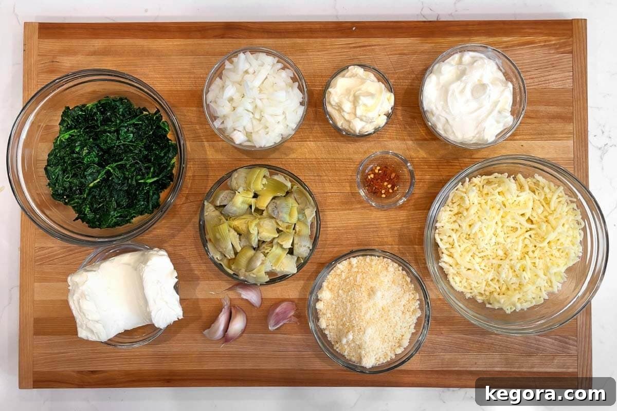 Slow Cooker Spinach Artichoke Dip ingredients shot on a board.